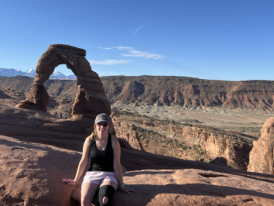Mara Irons posing in front of Delicate Arch at Arches National Park
